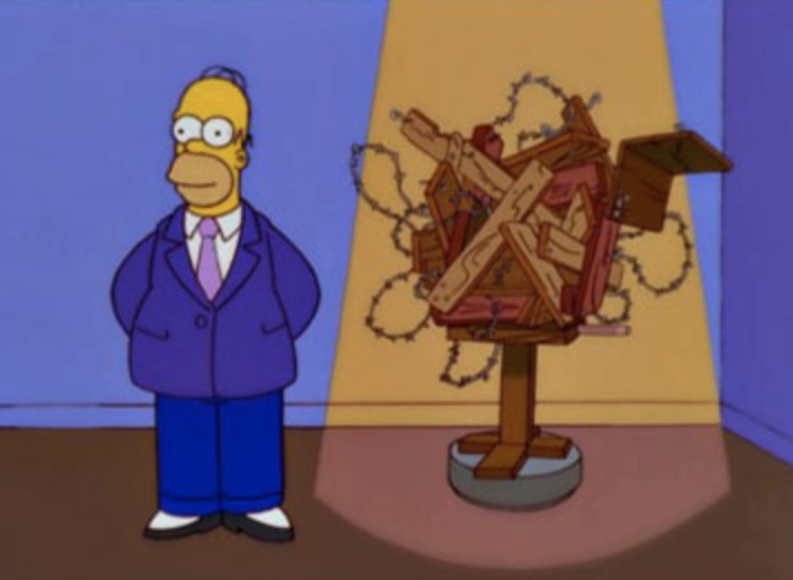 Homer Simpson stands next to a very poor art piece